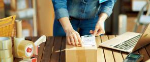 Frau verpackt Paket aus Online-Shop